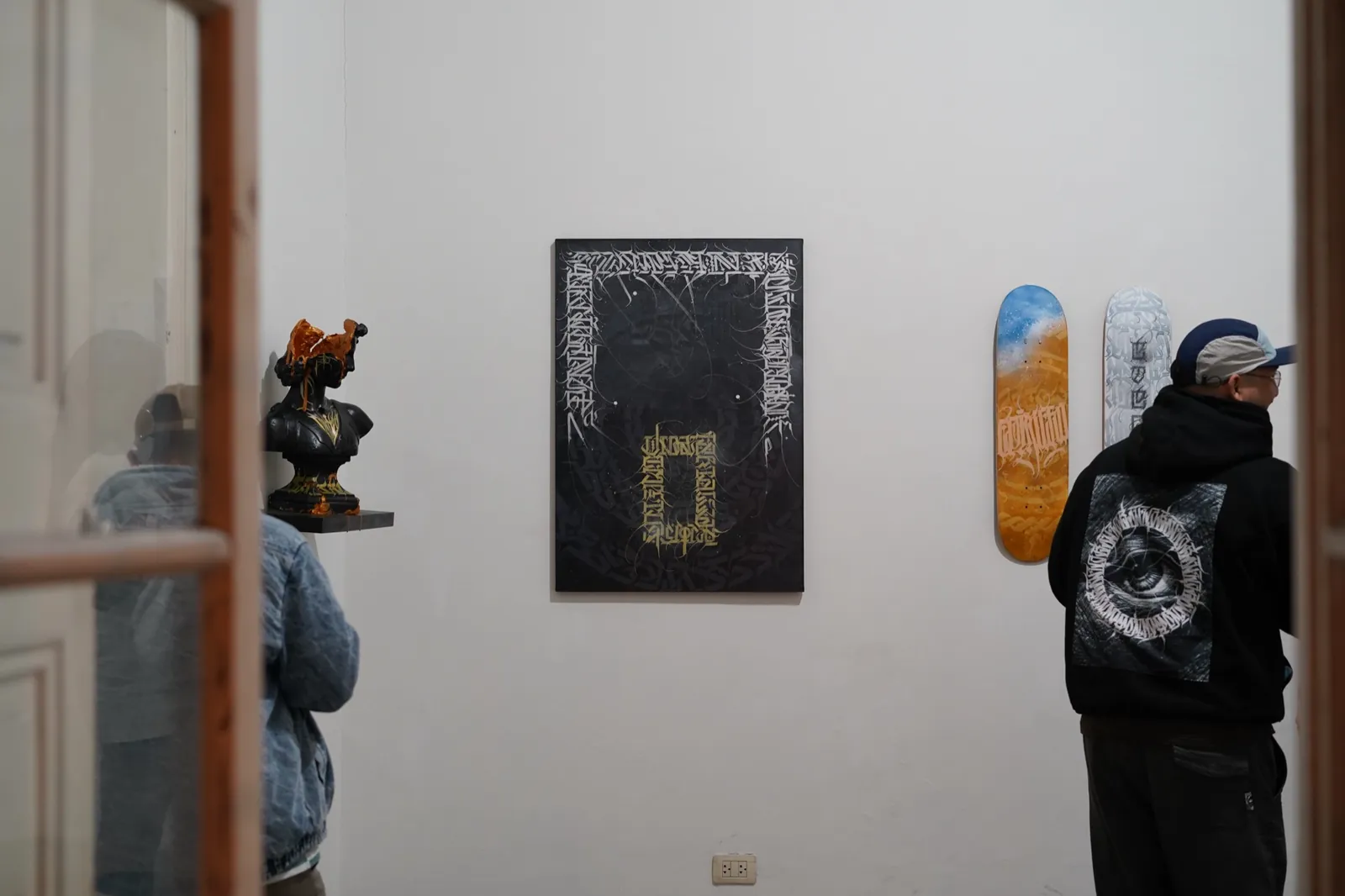Pared de la galería con obras y skates expuestos durante Manifiesto